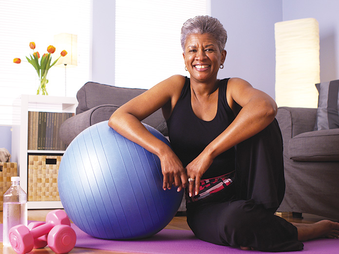 Woman in a SilverSneakers fitness class holding a weighted medicine ball