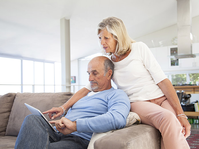 Image of a woman and man looking at HMO-POS plans on a tablet